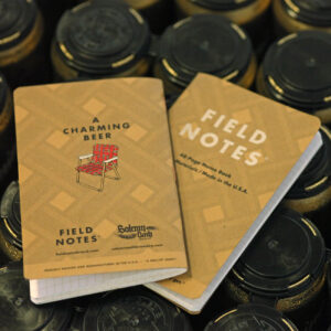 Field Notes mit A Charming Beer, zwei Notizhefte liegen auf Bierdosen